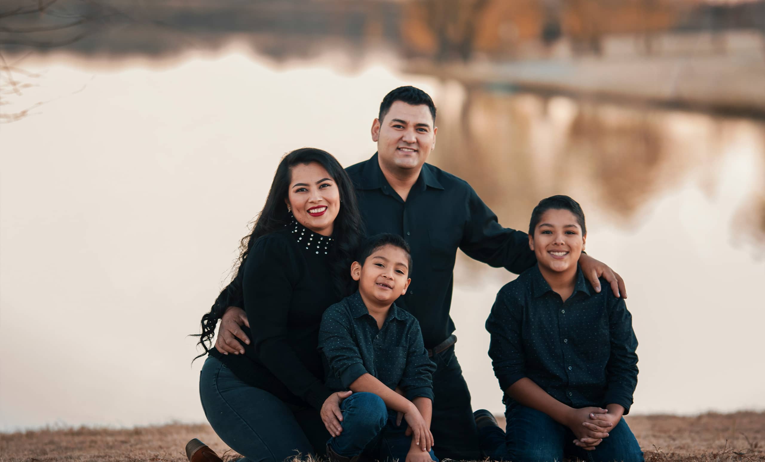 hispanic family together smiling near the lake